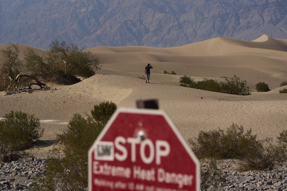 A person walks on sand dunes Sunday, Aug. 3, 2025, in Death Valley National Park, Calif. (AP Ph ...