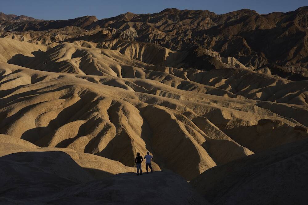 People look at the landscape at Zabriskie Point, Sunday, Aug. 3, 2025, in Death Valley National ...