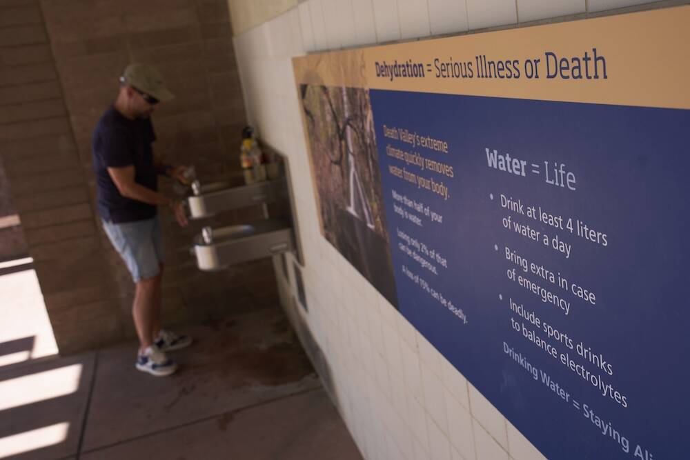 Pedro Luque, of Spain, fills up water bottles at the Furnace Creek Visitor Center, Sunday, Aug. ...