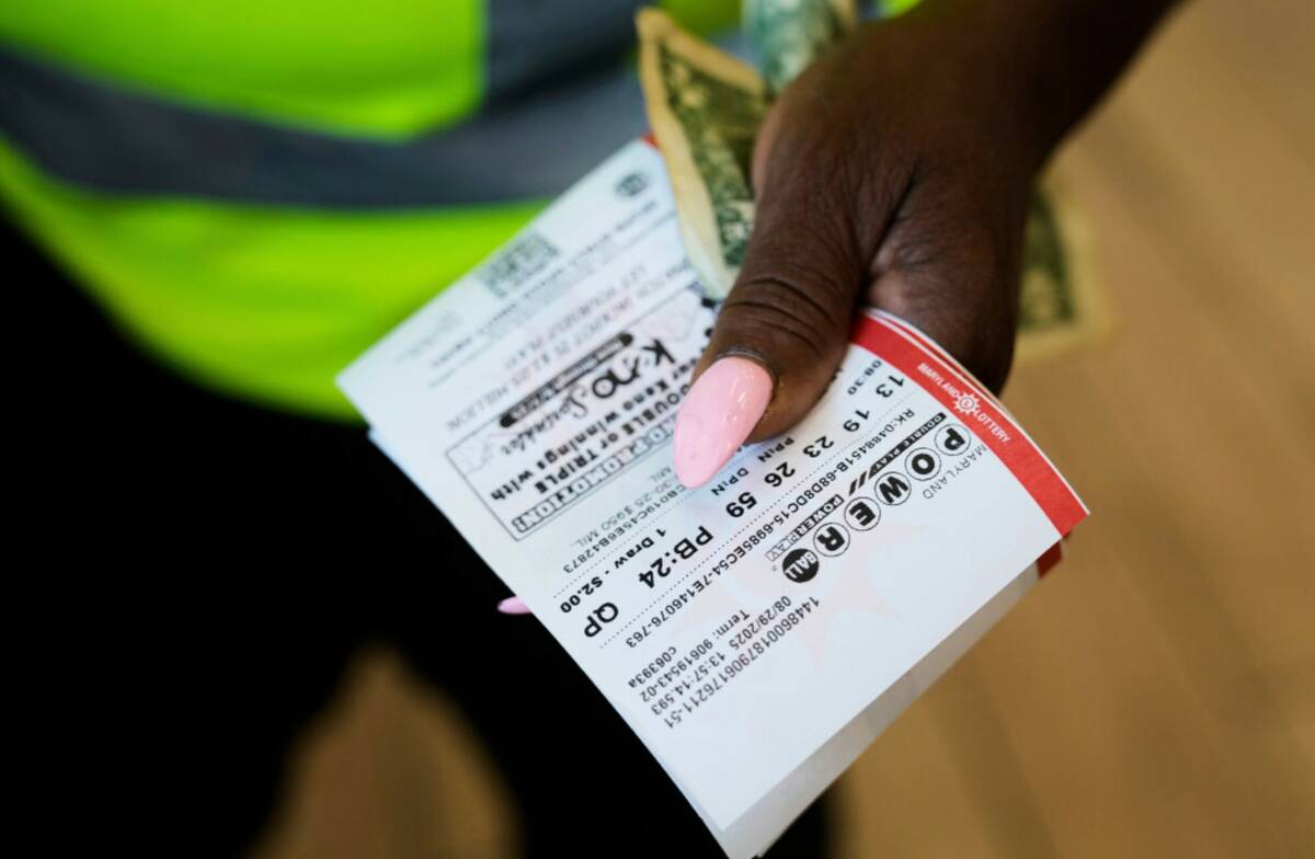 Roslyn Jefferson holds her Powerball lottery tickets ahead of Saturday's Powerball drawing offe ...