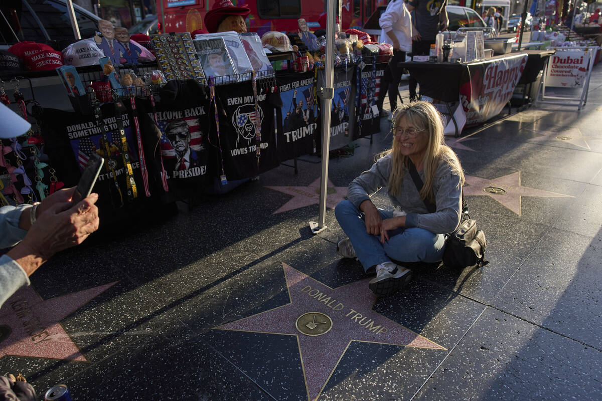 Silvia Camino, visiting from Argentina, takes photos with the Donald Trump star on the Hollywoo ...
