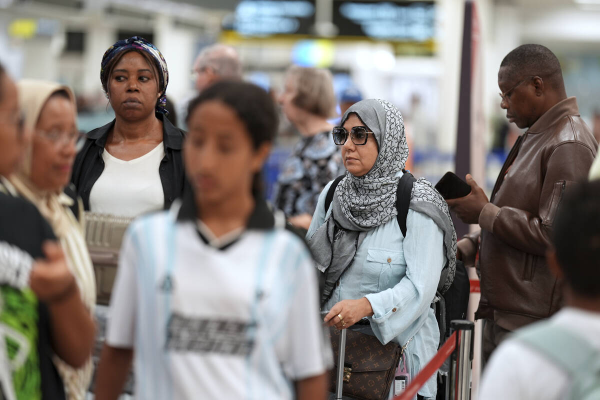 Travelers check in for international flights in the Miami International Airport at the start of ...