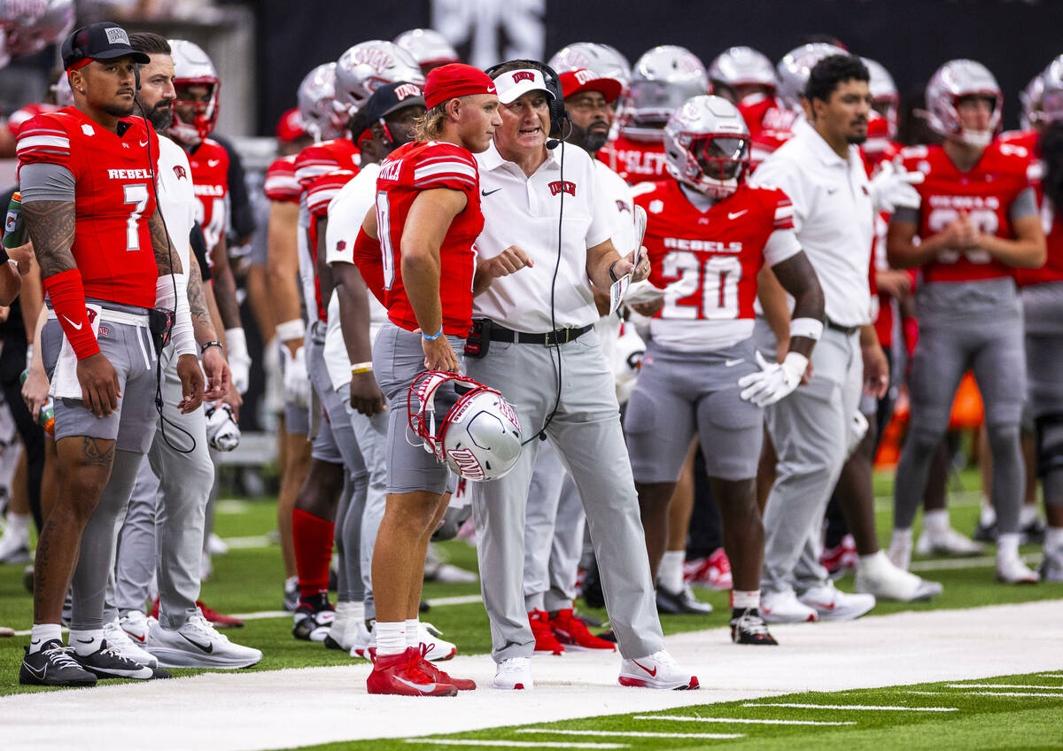 UNLV quarterback Anthony Colandrea (10) listens to head coach Dan Mullen as they talk on the si ...