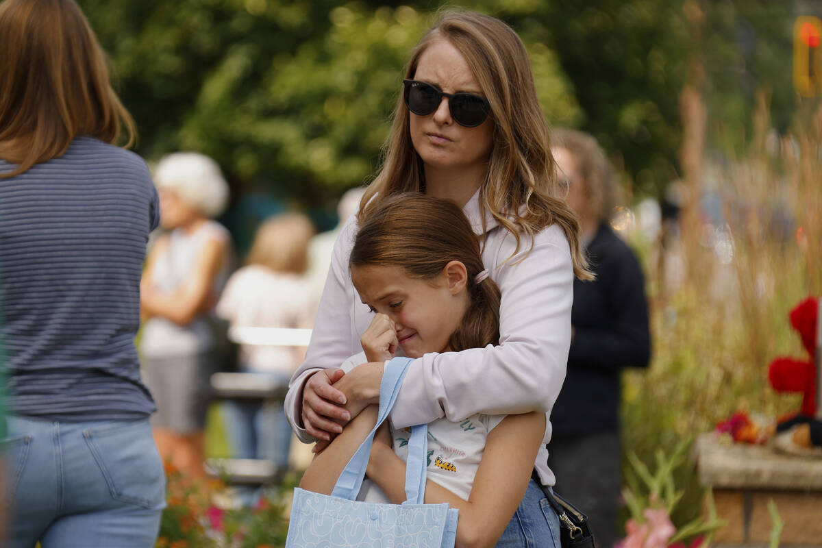 A child gets emotional at a make-shift memorial at Annunciation Catholic Church after the Wedne ...