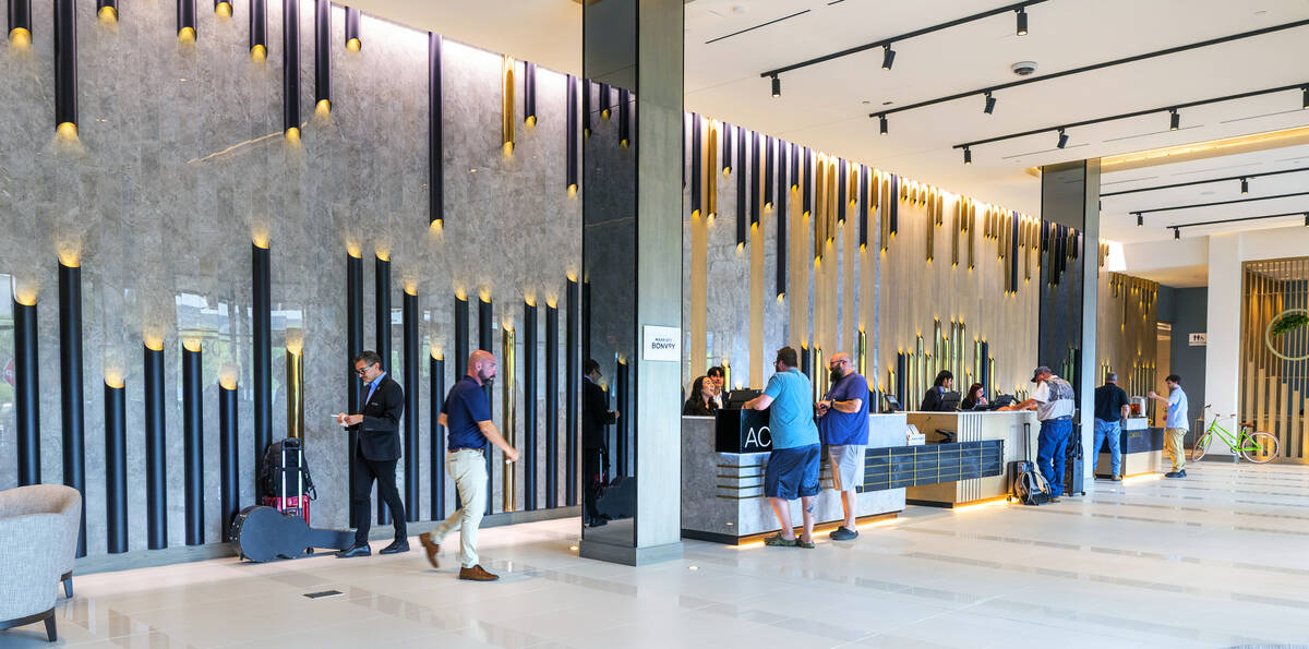 Staff and guests move about the front desk and main lobby of the new AC / Element Hotel Symphon ...