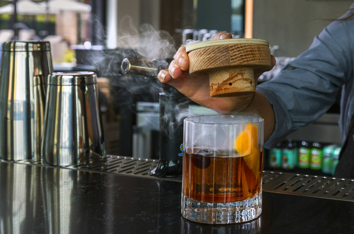 Bartender Tawny Shoemaker creates a smoked old fashion with a signature lapse Demerara syrup dr ...