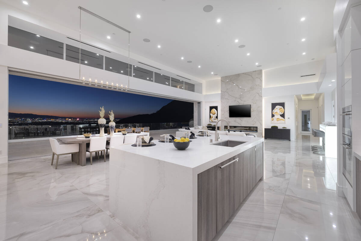 The kitchen displays a timeless motif with predominantly white cabinetry, contrasted by lower w ...