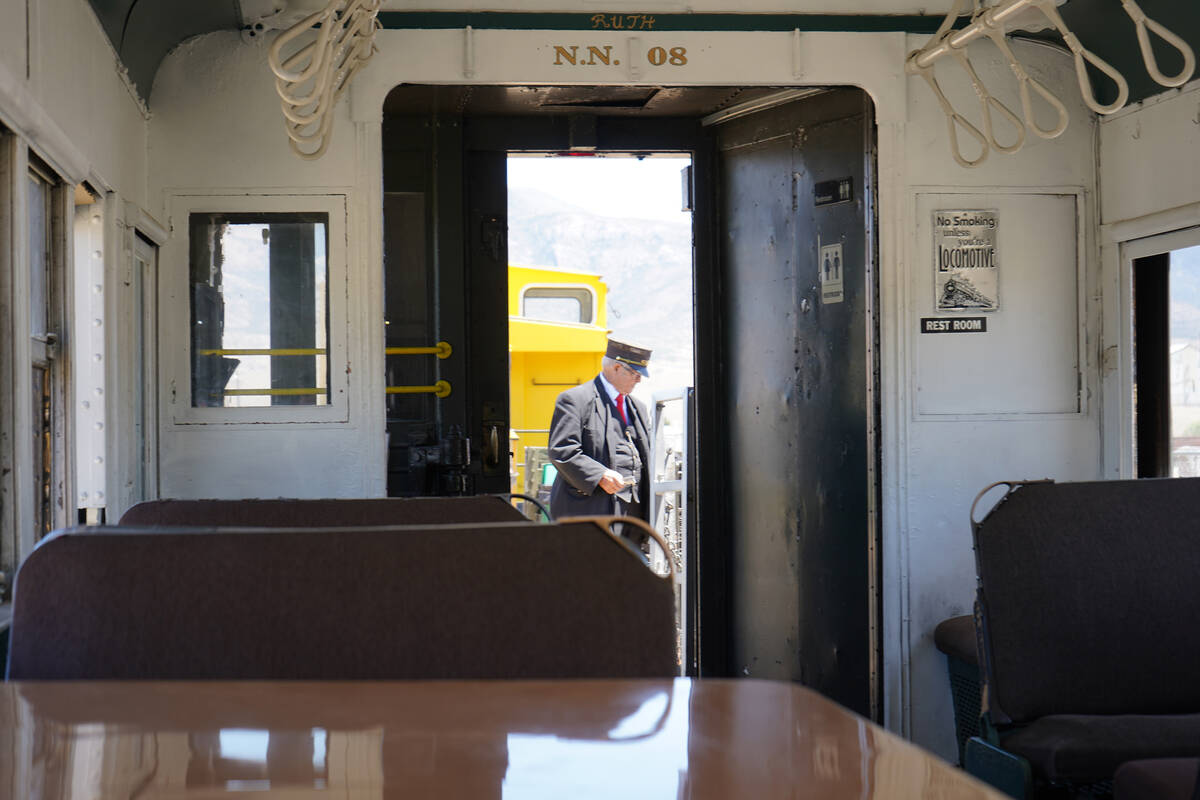 A Nevada Northern Railway conductor checks over details in the outdoor observation car before t ...
