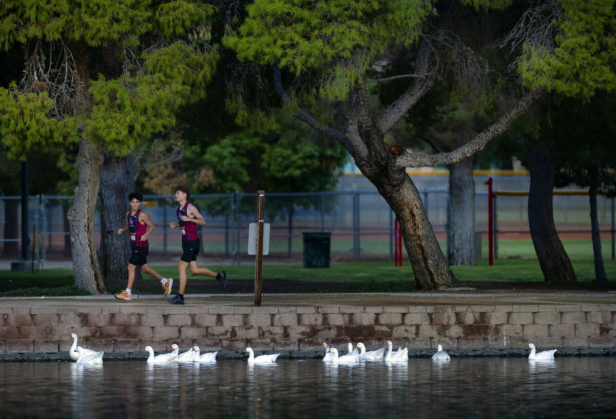 Las Vegas High School runners David Dollman (968) and Owen Miller (970) warm up around the lake ...