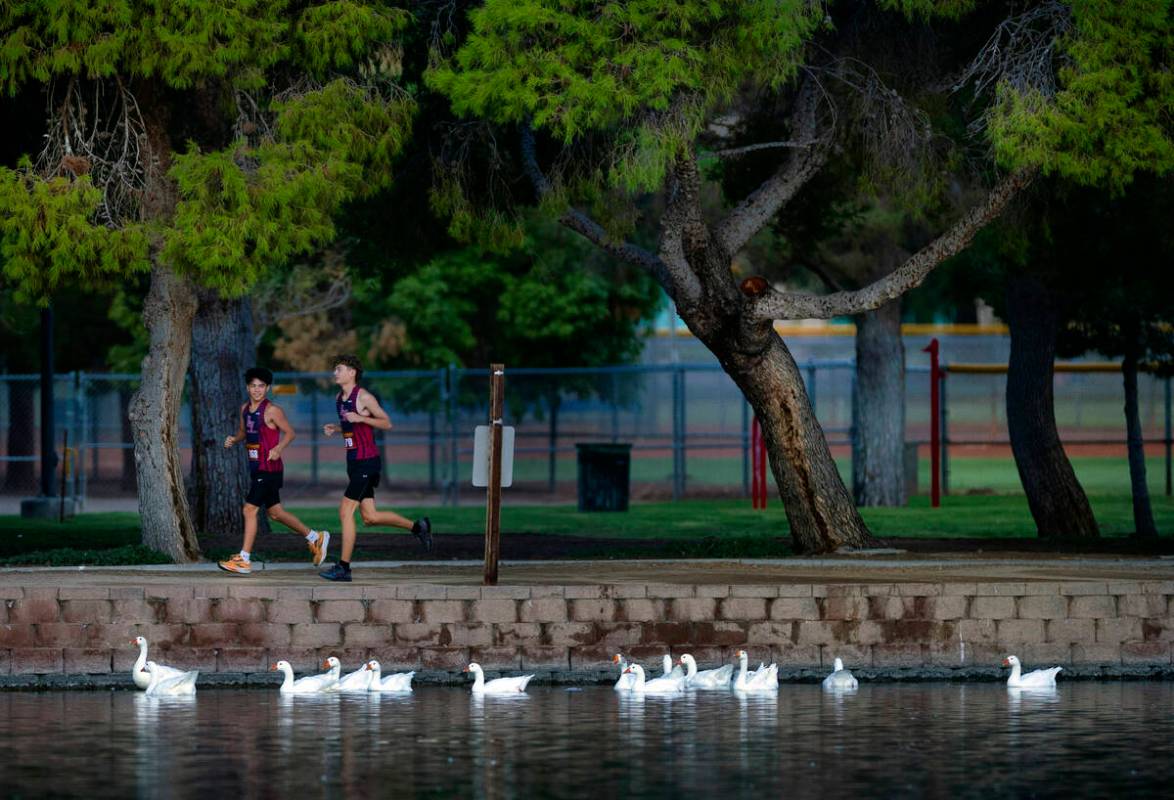 Las Vegas High School runners David Dollman (968) and Owen Miller (970) warm up around the lake ...