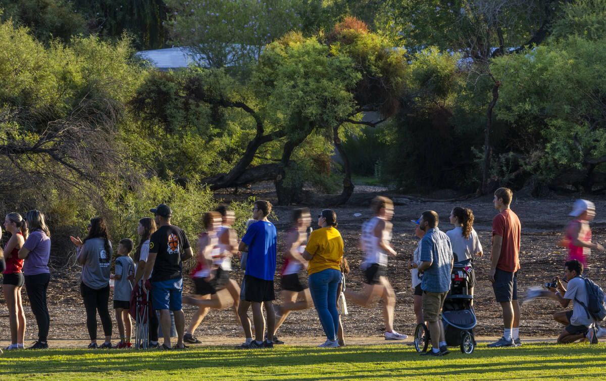 The crowd lines the course in supports as the Varsity A Boys competitors stream by during the 5 ...