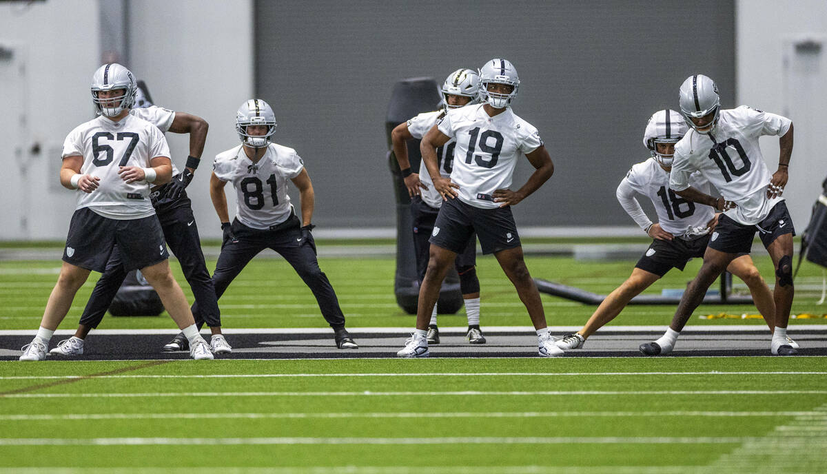 Raiders wide receiver Amari Cooper (19) stretches with teammates during practice at the Intermo ...