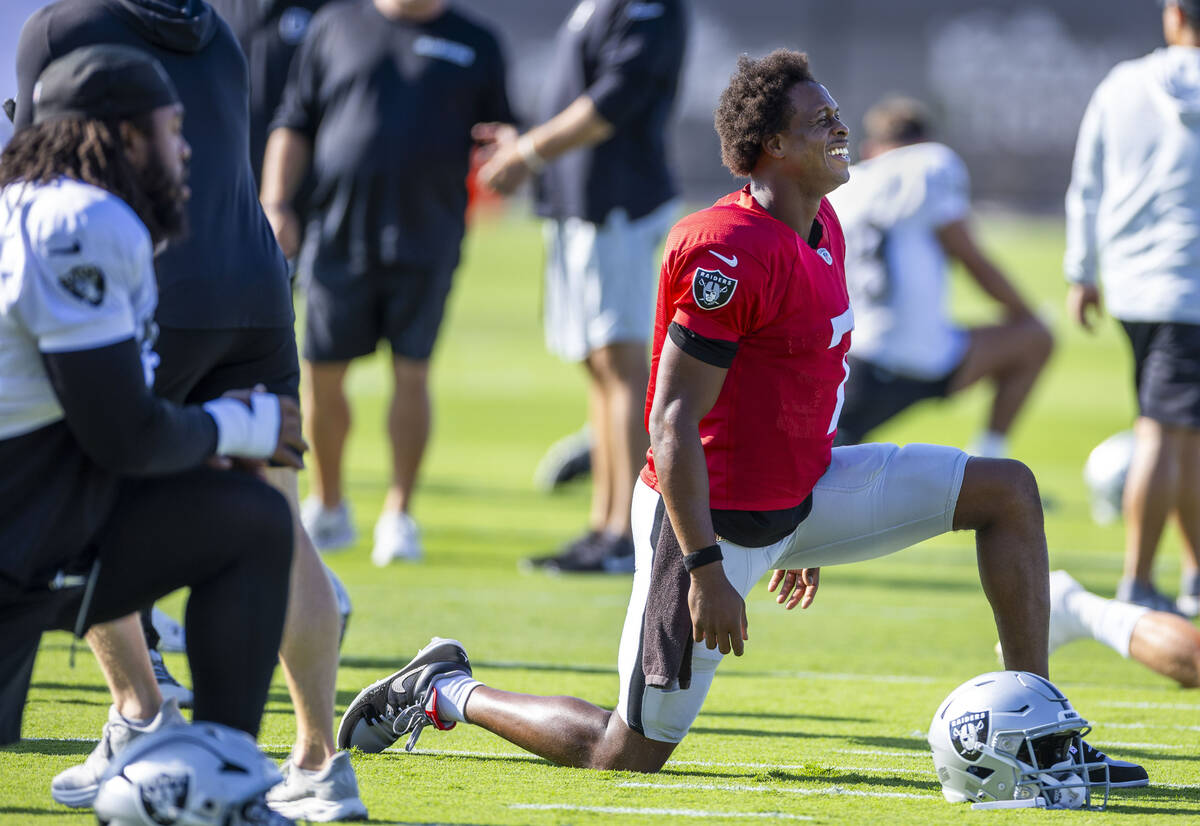 Raiders quarterback Geno Smith (7) laughs as he stretches during warm ups at the Intermountain ...