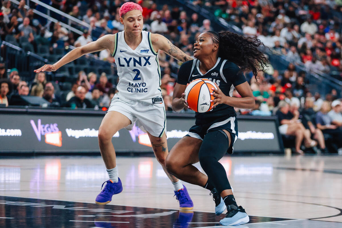 Aces guard Dana Evans (11) drives the ball towards the net as Minnesota Lynx guard Natisha Hied ...