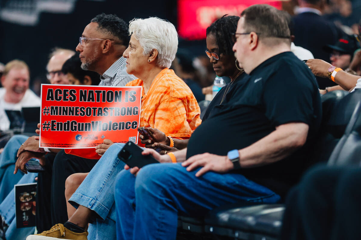 An Aces fan holds up a sign in support of ending gun violence during a WNBA basketball game bet ...