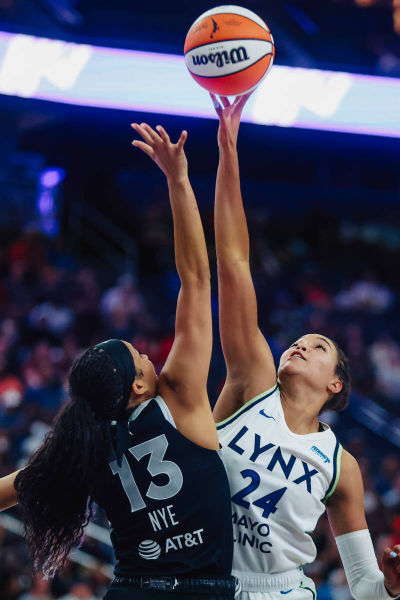 Aces guard Aaliyah Nye (13) and Minnesota Lynx forward Napheesa Collier (24) reach for the ball ...