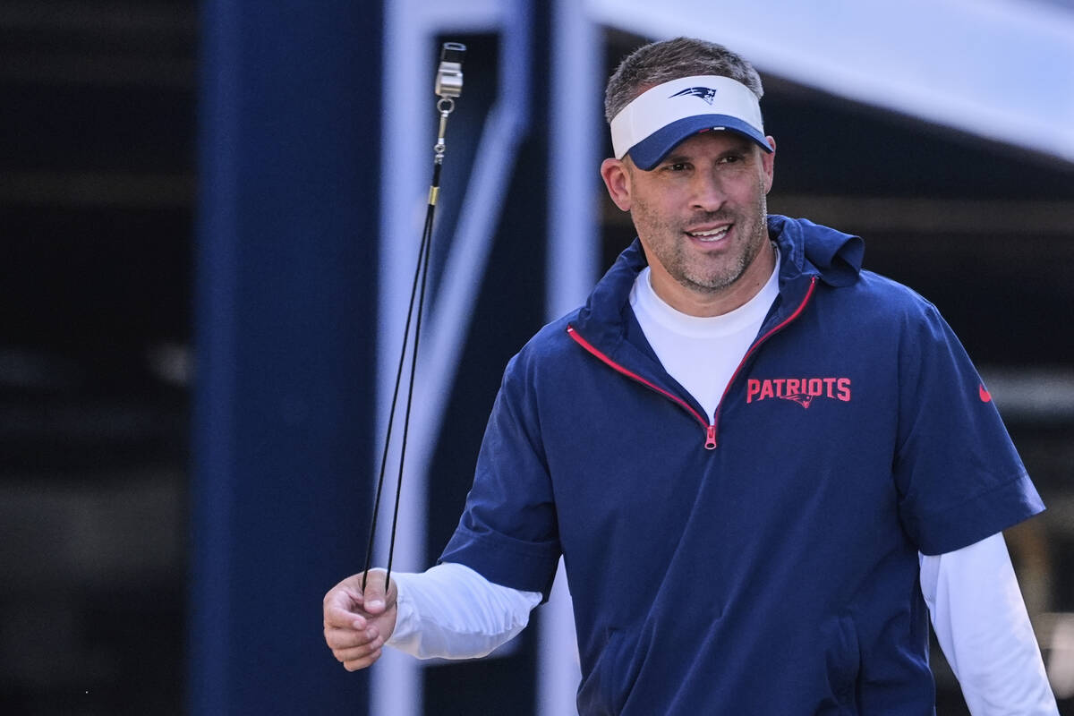 New England Patriots offensive coordinator Josh McDaniels twirls a whistle while walking to the ...