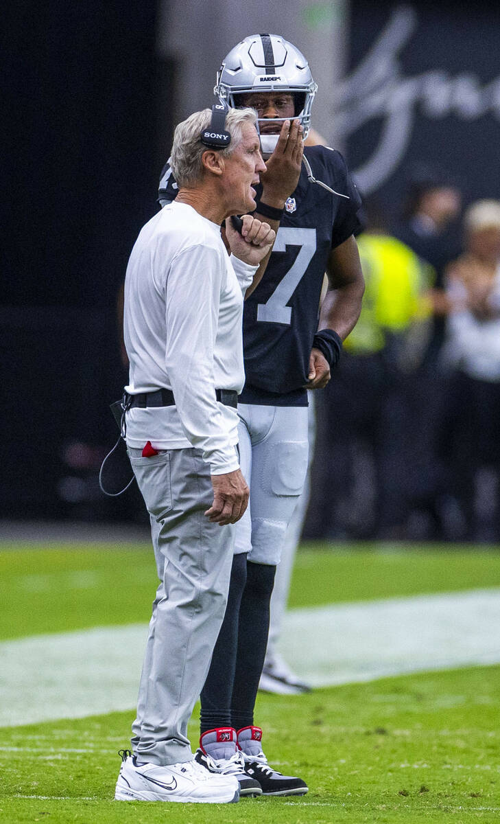 Raiders head coach Pete Carroll talks with quarterback Geno Smith (7) against the San Francisco ...