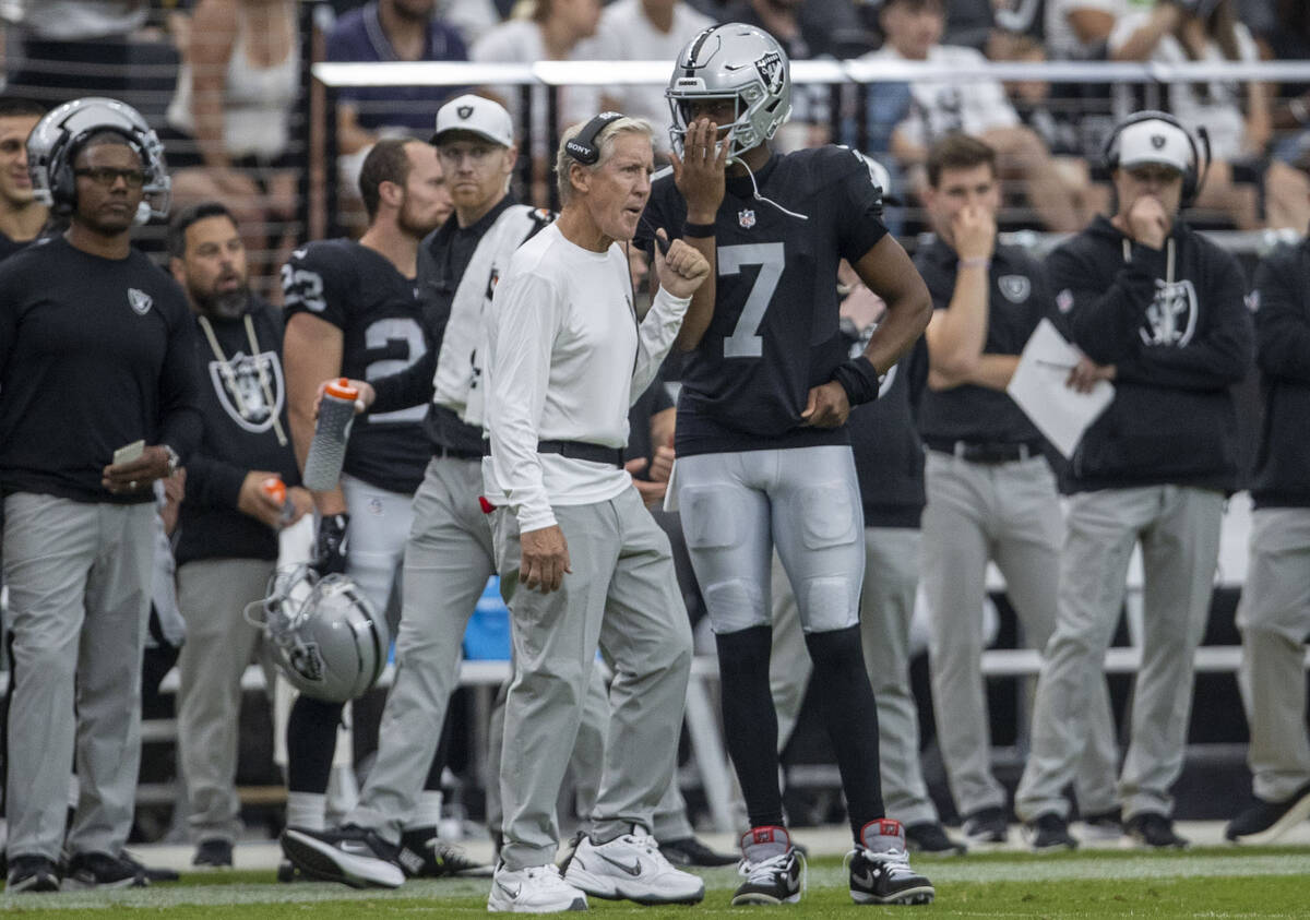 Raiders quarterback Geno Smith (7) speaks with head coach Pete Carroll on the sideline during t ...