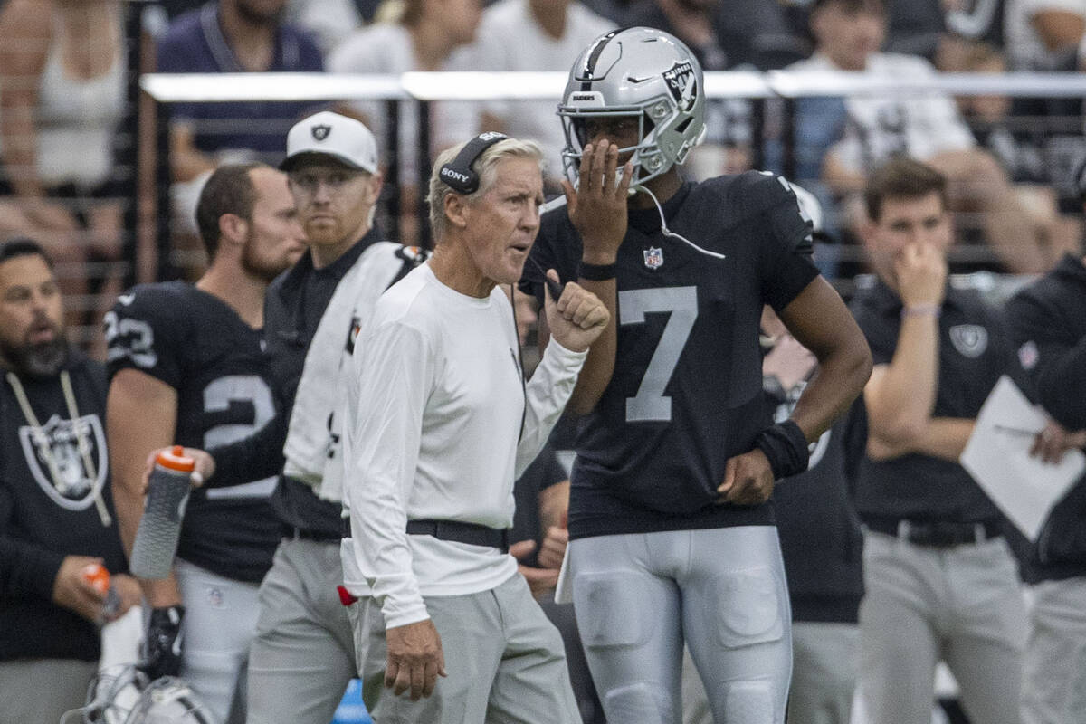 Raiders quarterback Geno Smith (7) speaks with head coach Pete Carroll on the sideline during t ...