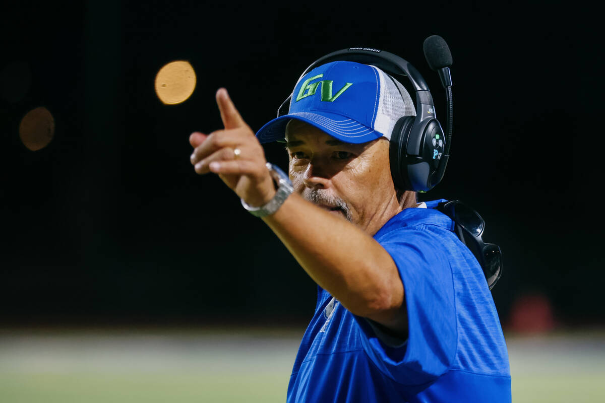 Green Valley head coach Bill Powell communicates with his players during the football game agai ...