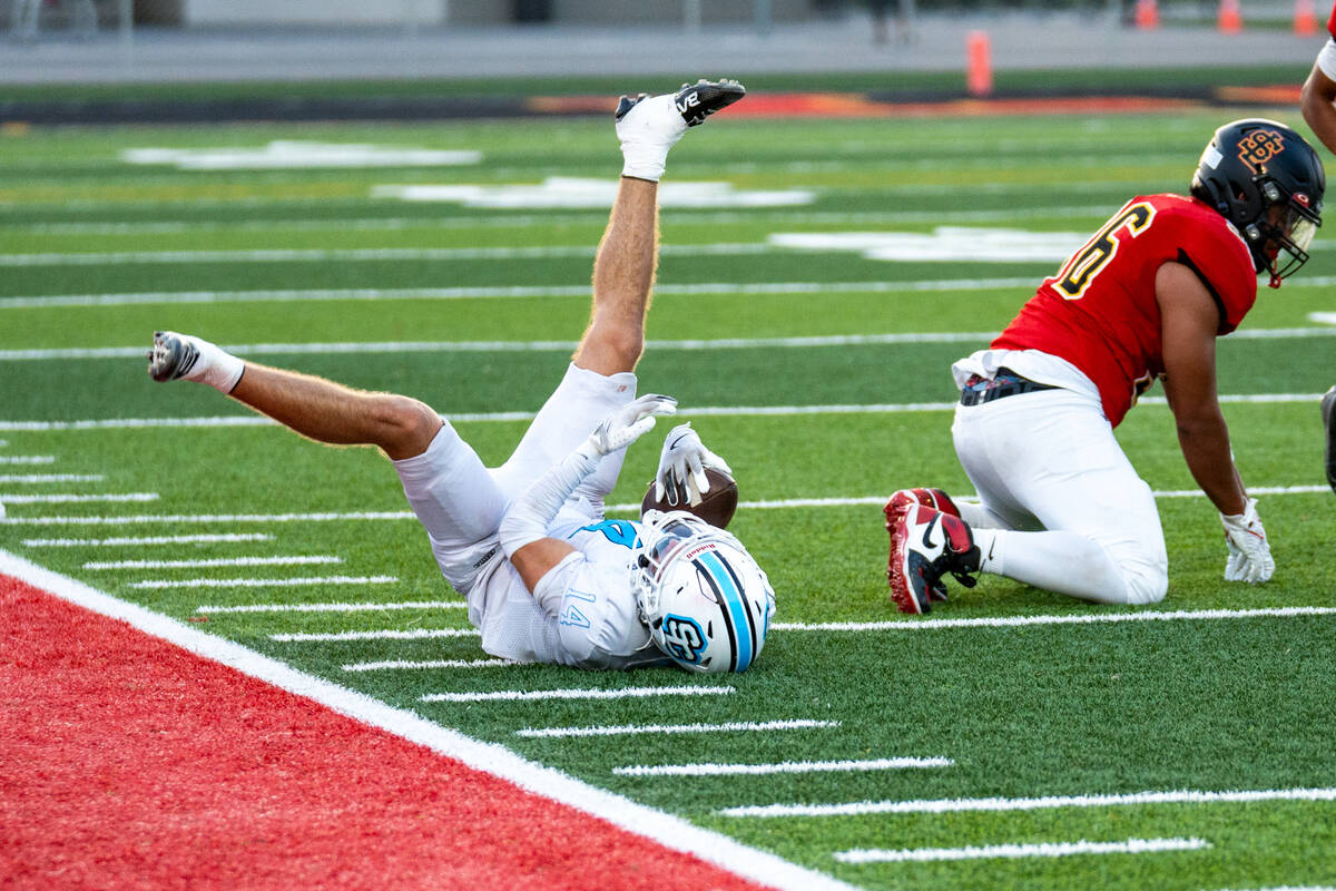 Sloan Canyon's Christian Rhodes hits the ground after catching a pass during a football ga ...