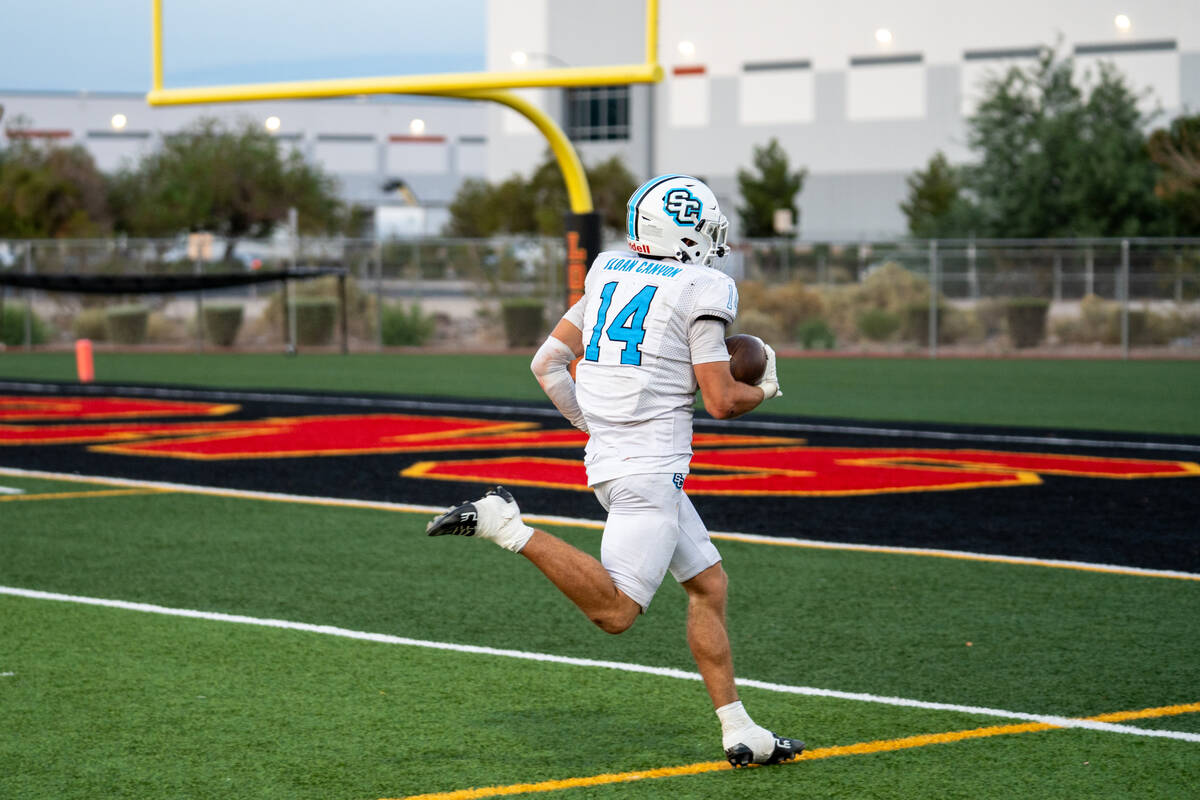 Sloan Canyon's Christian Rhodes runs into the end zone during a football game against Lose ...