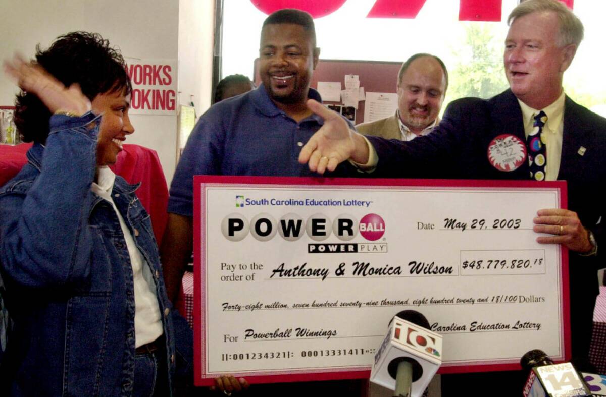 South Carolina Education Lottery Director, Ernie Passailaigue , right, extends his hand to Moni ...
