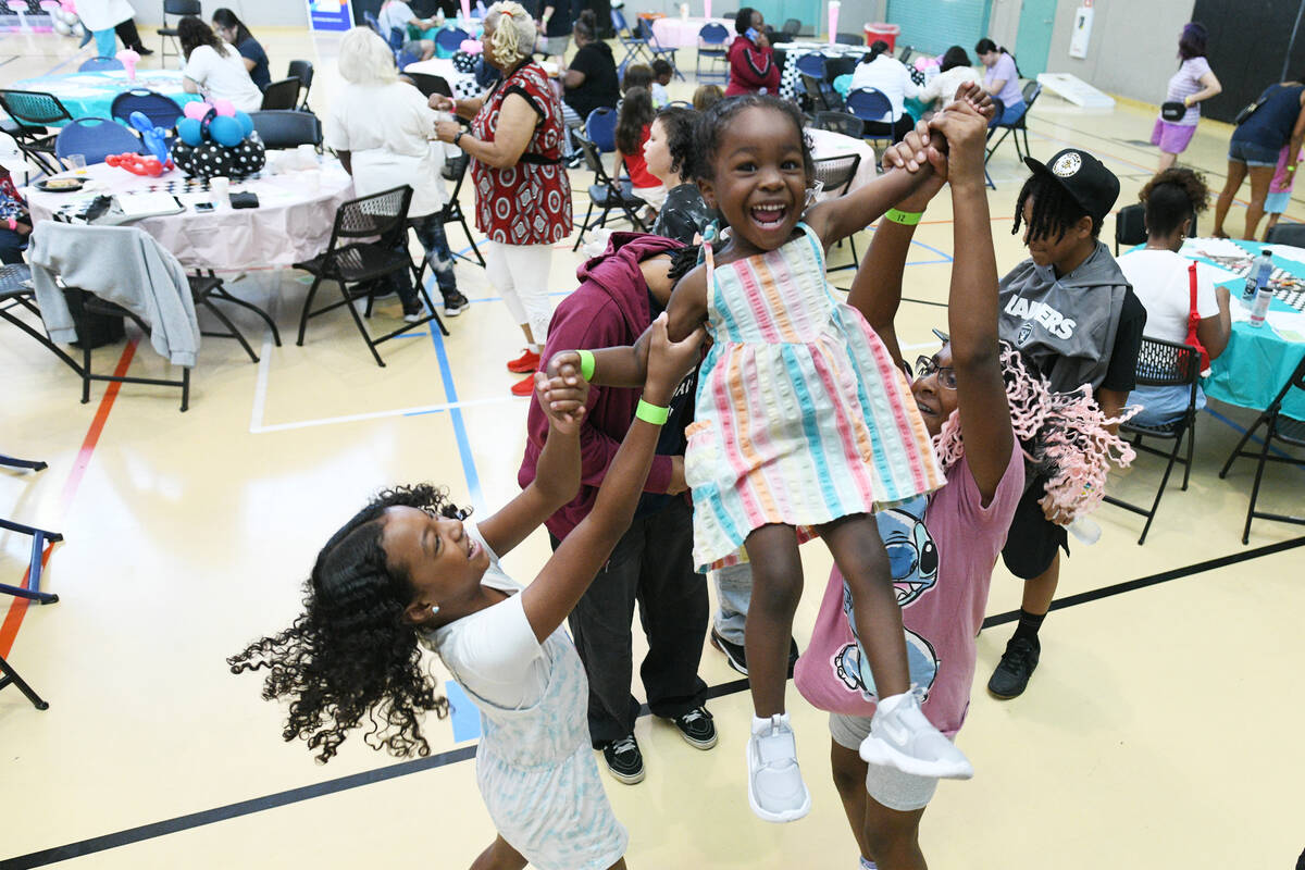 Adriann Marshall is tossed in the air by her sister Aaliyah Marshall, left, and Simone Sabbs du ...