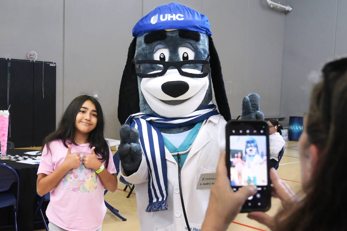 Dahlia Vaquez poses for a picture with UnitedHealthcare mascot Dr. Health E. Hound during an ev ...