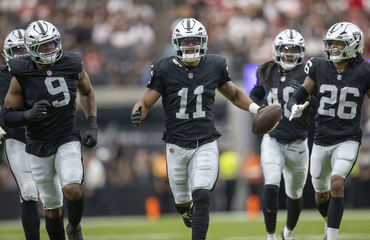 Raiders safety Jeremy Chinn (11) celebrates his interception with defensive end Tyree Wilson (9 ...