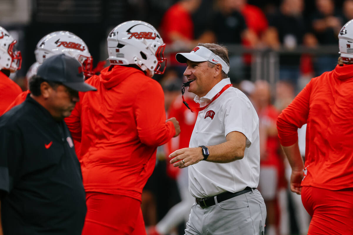 UNLV head coach Dan Mullen grins while greeting players during warmups before the football game ...