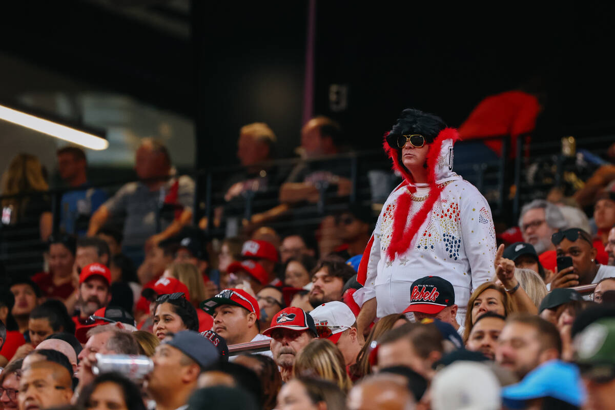 A UNLV fan dressed as Elvis stands and watches the game during the first half of the football g ...