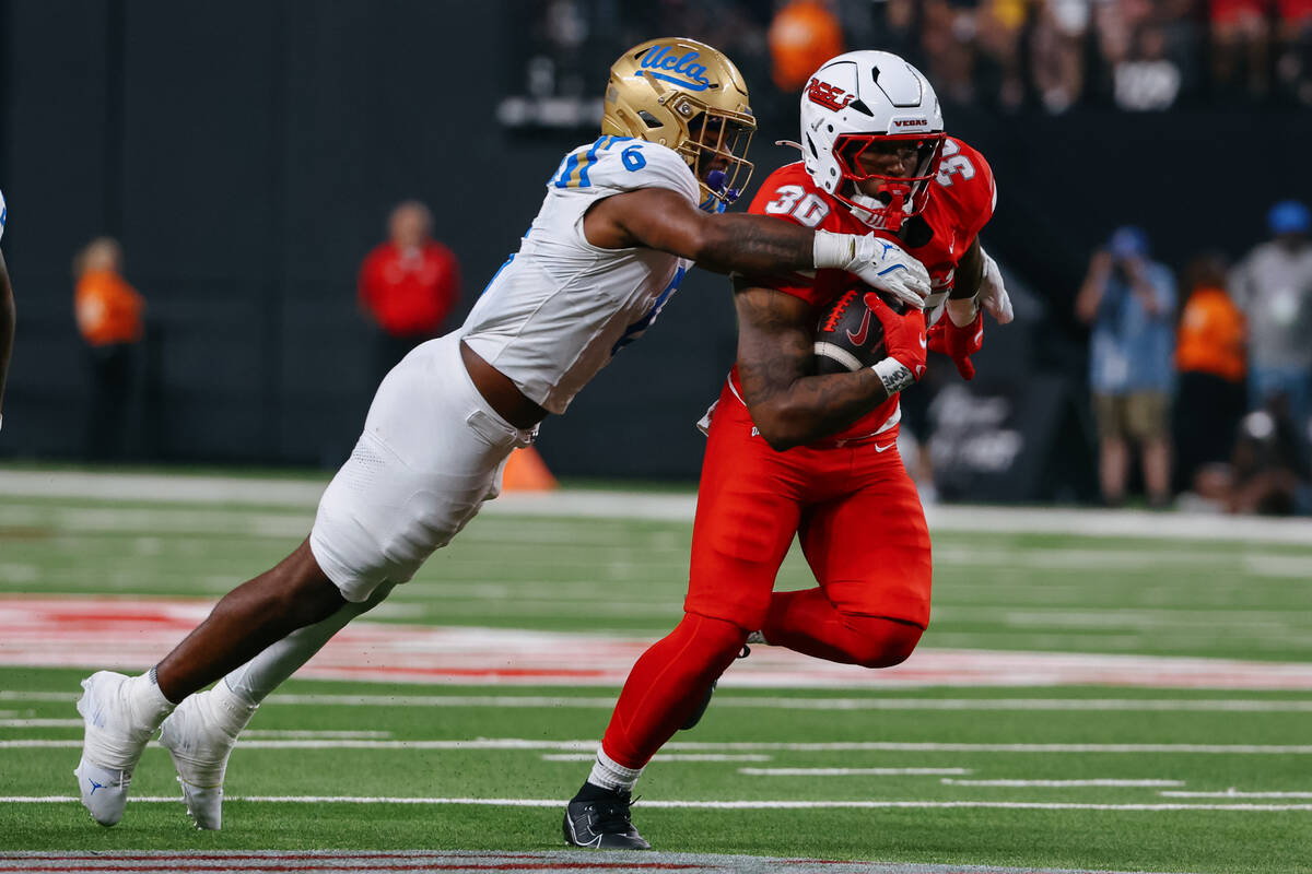 UCLA linebacker JonJon Vaughns (6) tackles UNLV tight end Var'Keyes Gumms (30) during the ...