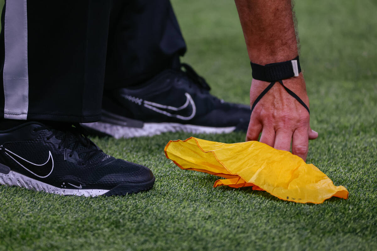 A referee picks up a flag during second half of the football game on Saturday, Sept. 6, 2025 at ...