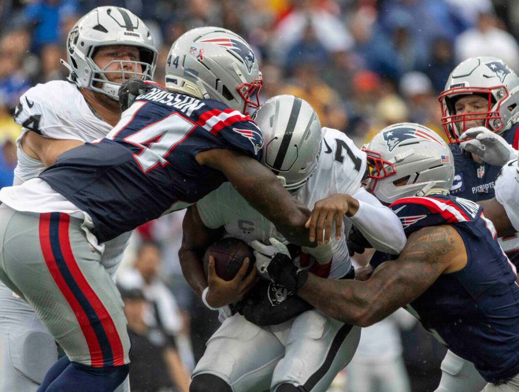 Raiders quarterback Geno Smith (7) is sacked by New England Patriots linebacker K'Lavon Ch ...