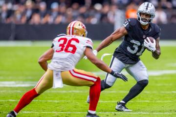 Raiders running back Raheem Mostert (31) looks to move around San Francisco 49ers safety Marque ...