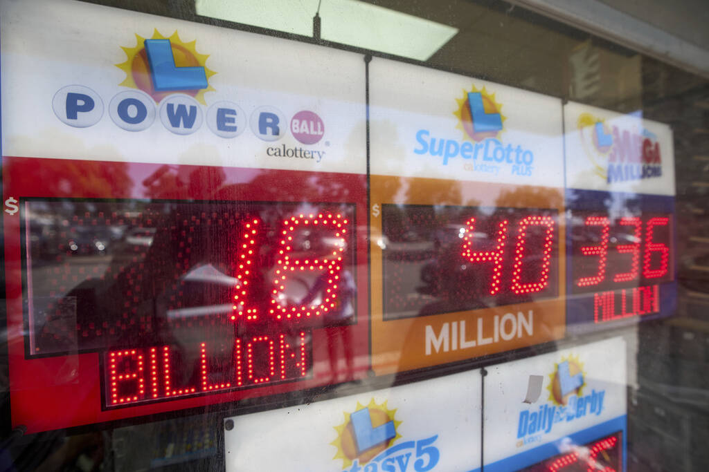 An electronic sign reads $1.8 billion as crowds wait in line to buy lottery tickets at the Blue ...