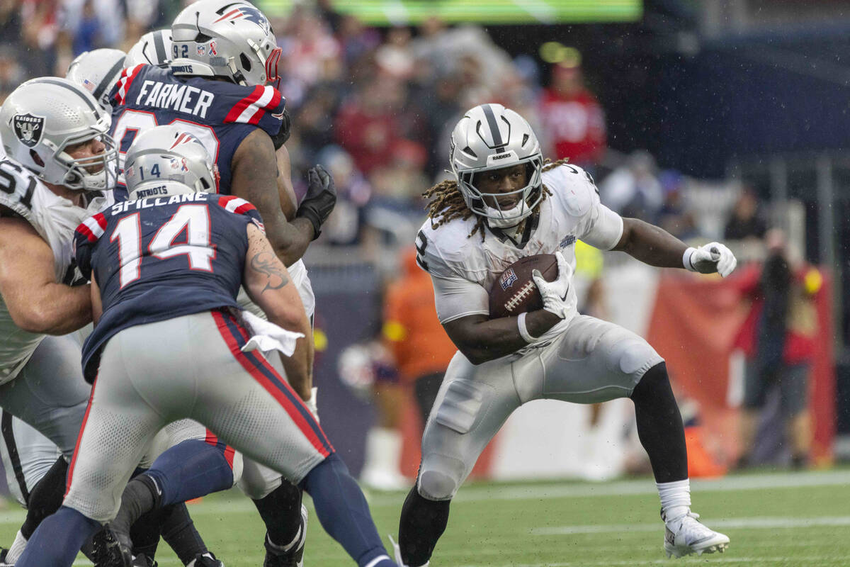 Raiders running back Ashton Jeanty (2) looks for room to run against New England Patriots lineb ...