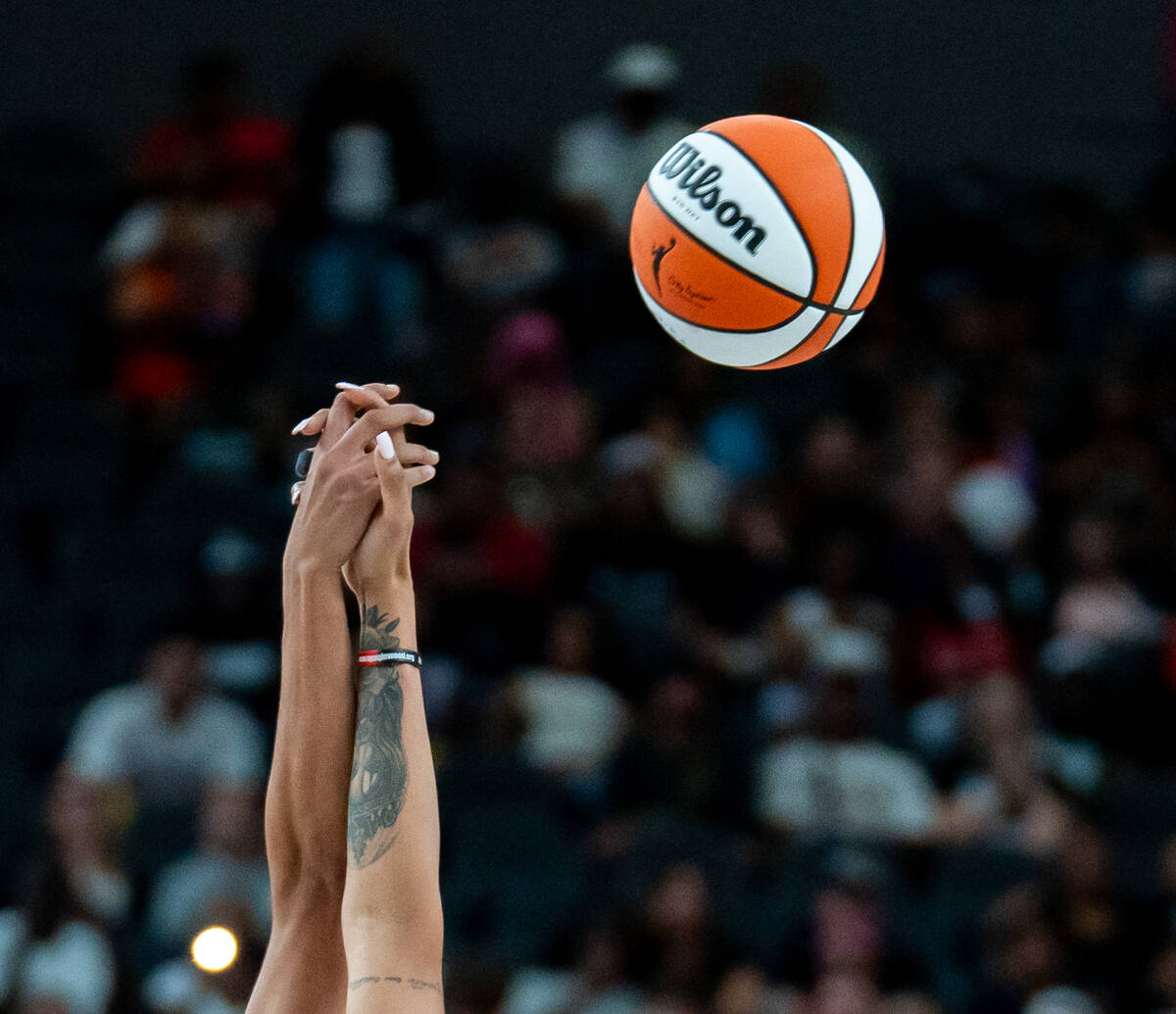 Players’ hands collide as a referee tosses the ball after the Aces won a challenge on a ...