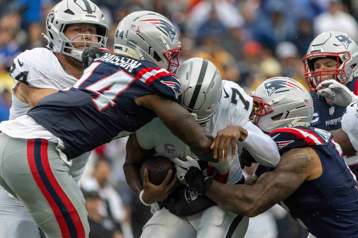 Raiders quarterback Geno Smith (7) is sacked by New England Patriots linebacker K'Lavon Chaisso ...