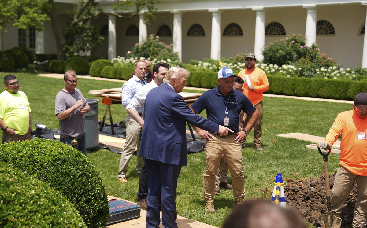 President Donald Trump looks over a construction project in the Rose Garden of the White House, ...