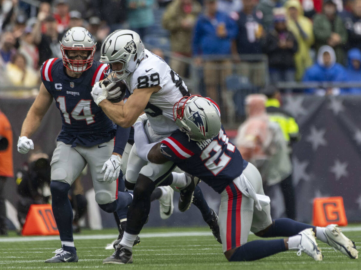 Raiders tight end Brock Bowers (89) is tackled by New England Patriots safety Jaylinn Hawkins ( ...