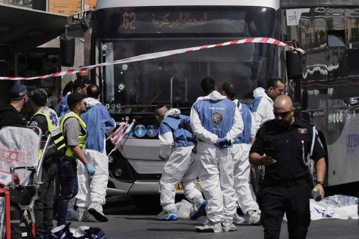 Israeli police and rescue teams inspect the scene of a shooting attack carried out by two Pales ...