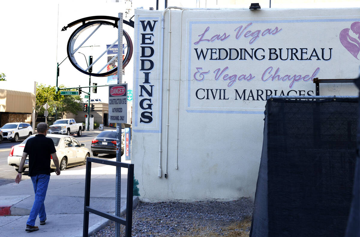 A pedestrian walks past a closed wedding chapel that sold this year at 320 S 3rd St., on Friday ...
