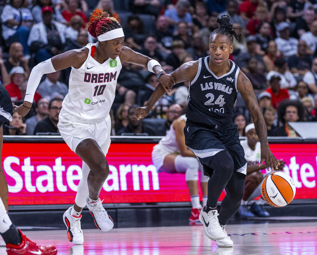 Atlanta Dream guard Rhyne Howard (10) grabs the arm of Aces guard Jewell Loyd (24) on the drive ...