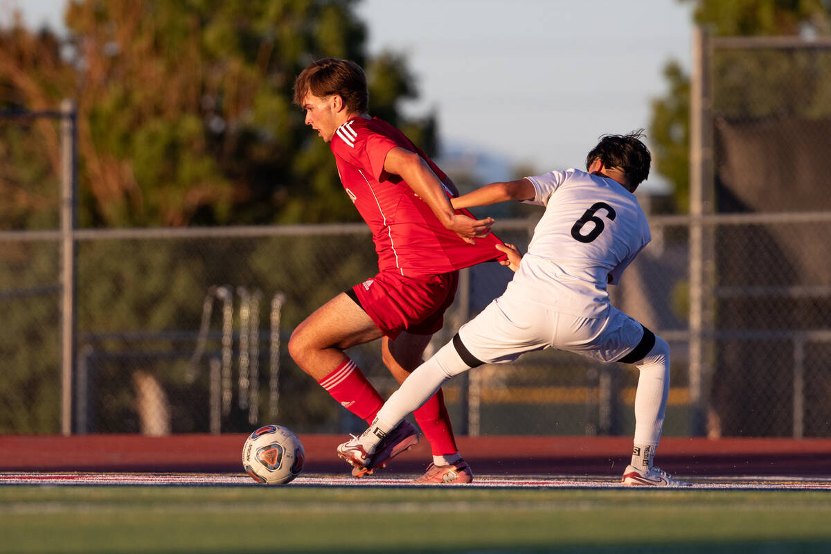 Coronado striker Gavin Flickinger (11) attempts to get past Israel Pelaez Jr (6) during a socce ...