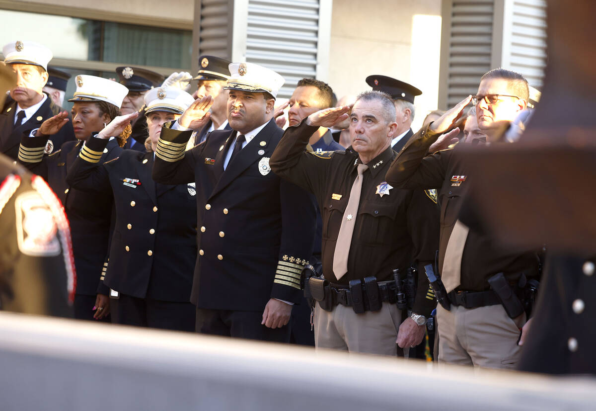 Attendees, including Undersheriff Andrew Walsh, second right, salute as a U.S. flag that once f ...