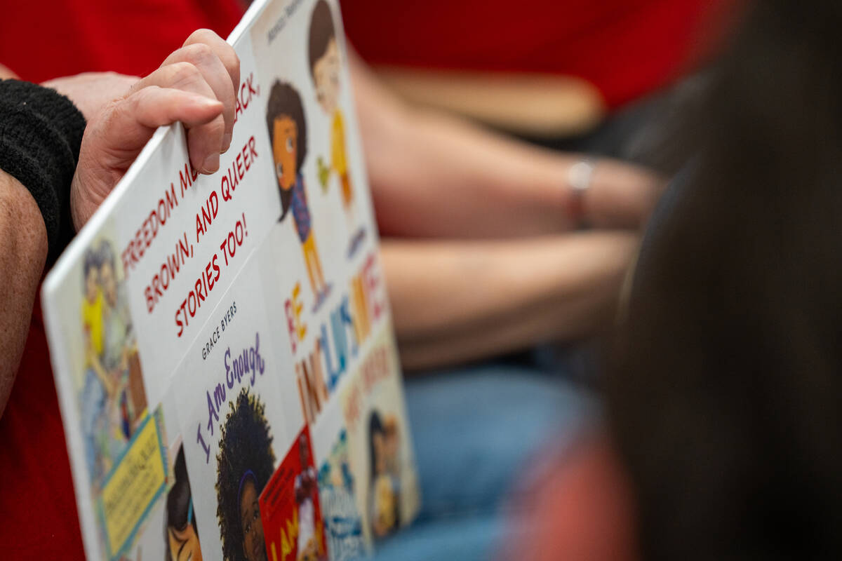 A community member holds a sign at Thursday's Clark County School Board meeting at the Edward A ...