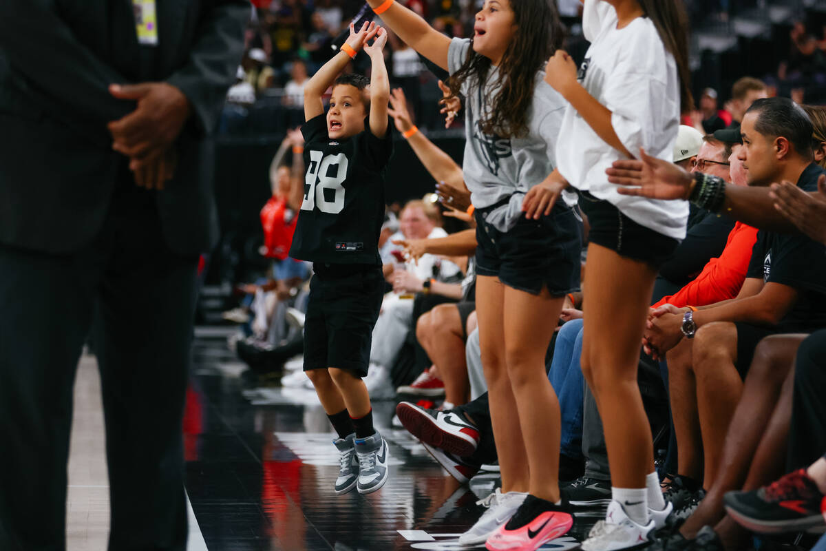 A young fan jumps up and down to try and get a free T-shirt during the first half of the Aces&# ...